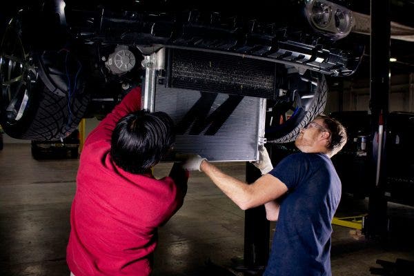 Jason and our newest project manager, Andrew, install the Mishimoto aluminum radiator into the Challenger.