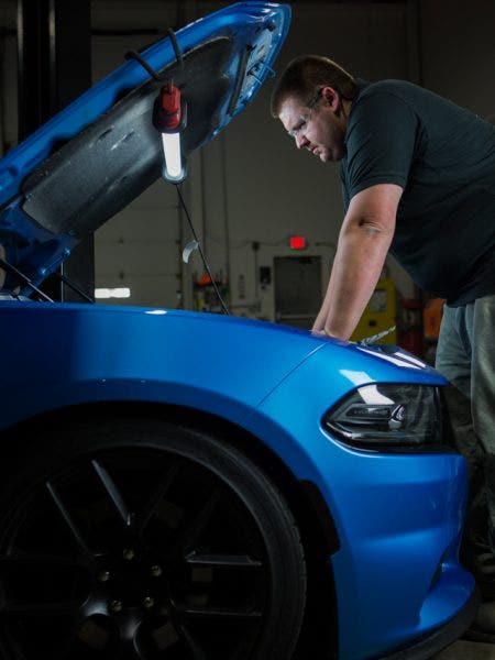 Our engineer, Dan, inspects the engine bay of our 2015 Charger R/T loaner for the best place to mount our catch can.