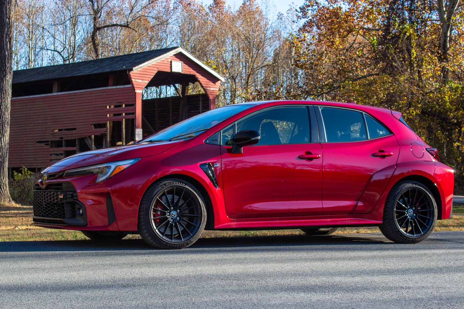 An image of a 2023 Toyota GR Corolla in front of a covered bridge.