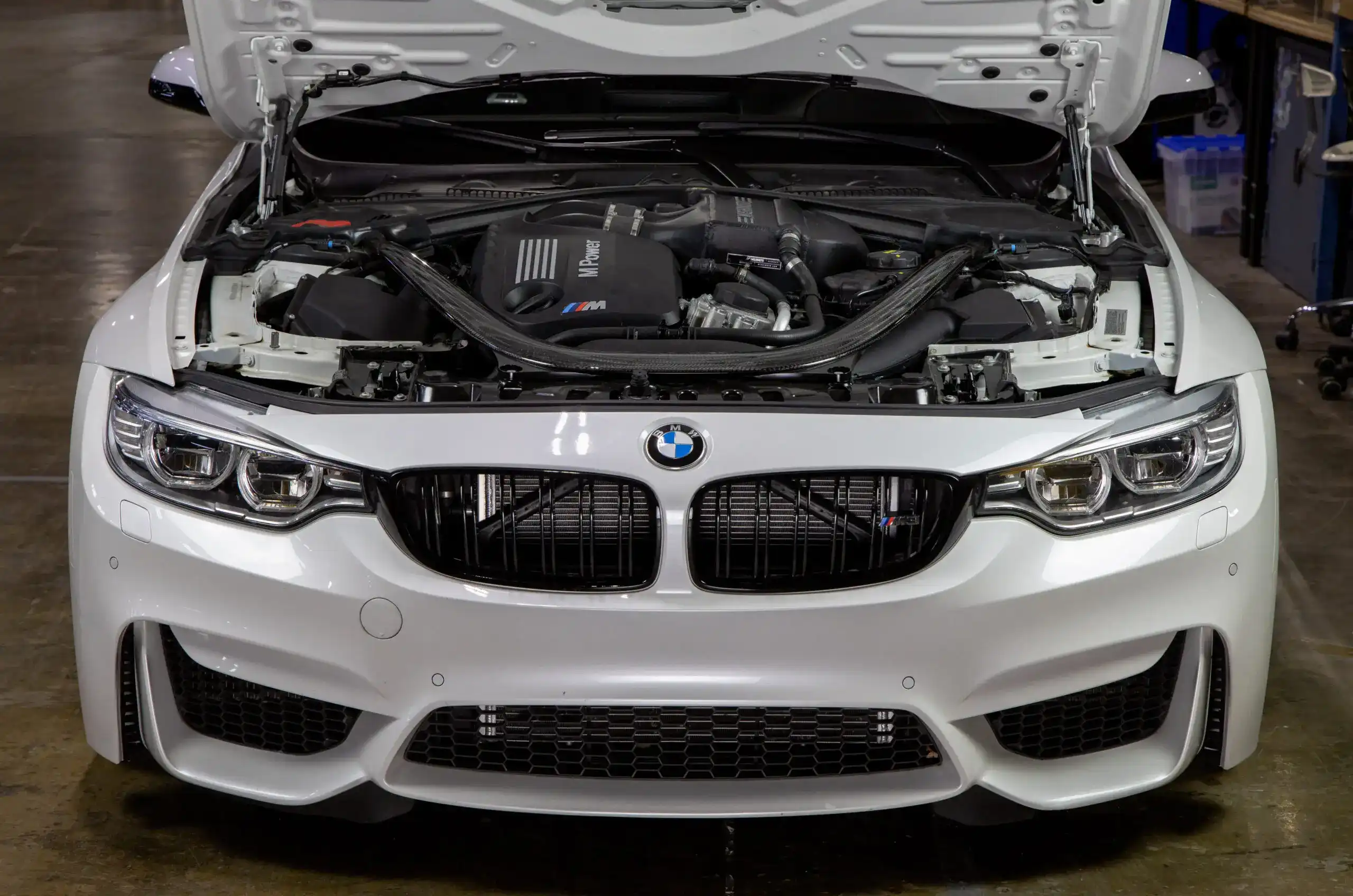 BMW with its hood open showcasing the engine bay.