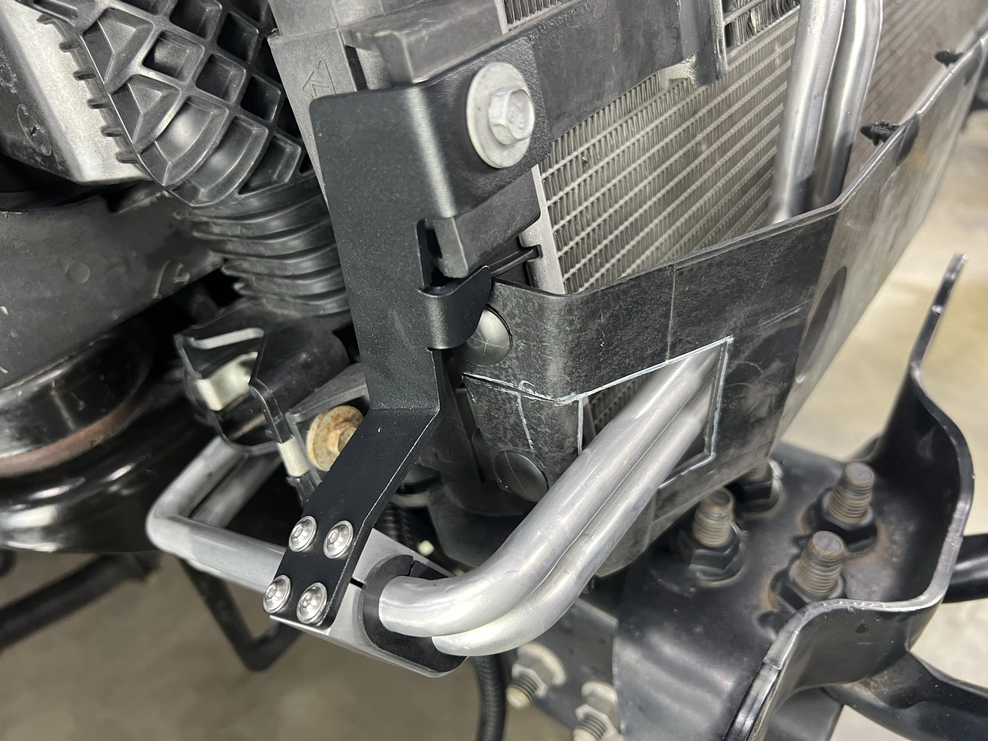 An image of the CNC-machined brackets that secure the transmission fluid lines.