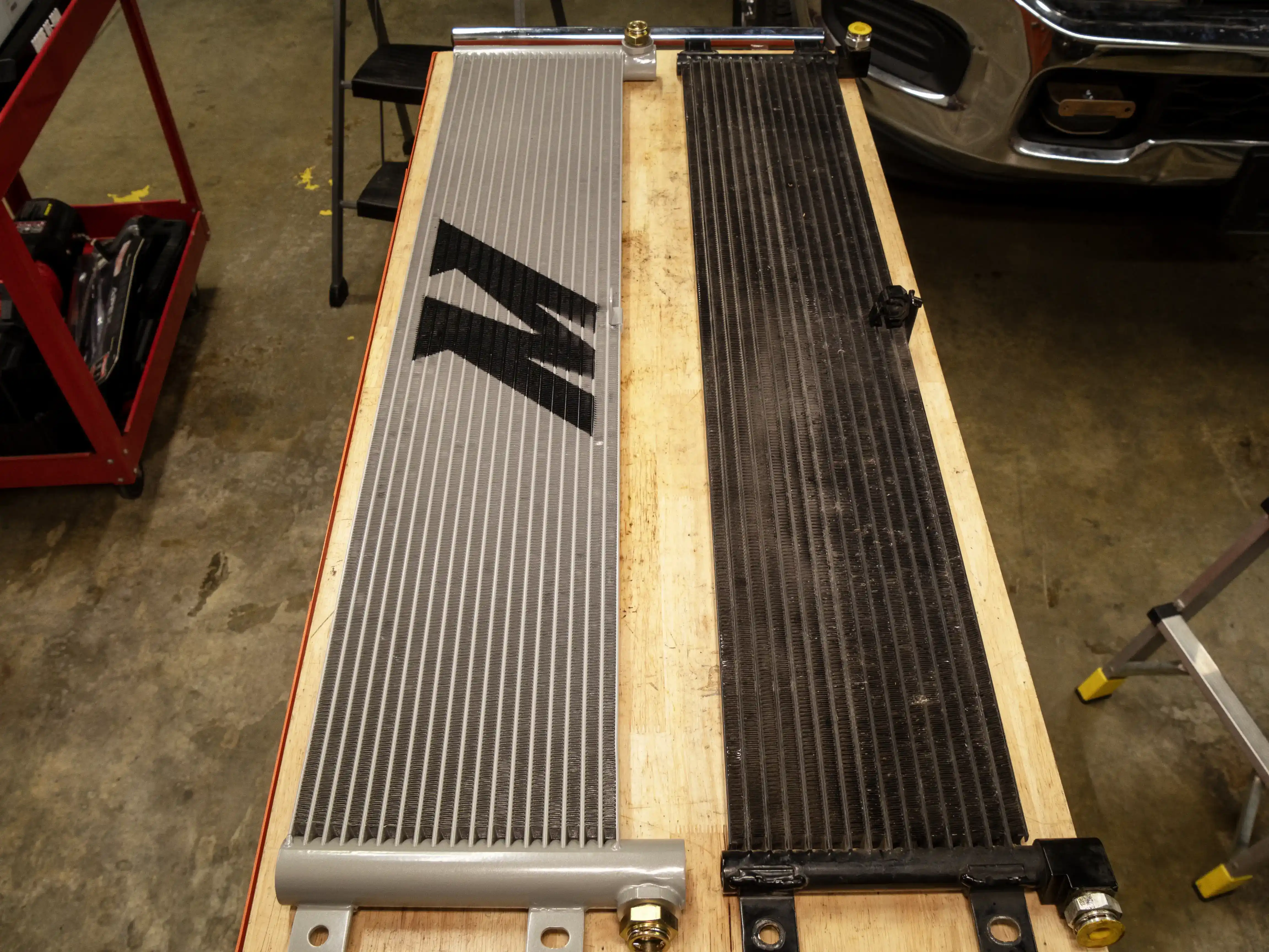 A side-by-side image comparing the Mishimoto Transmission Cooler and stock.